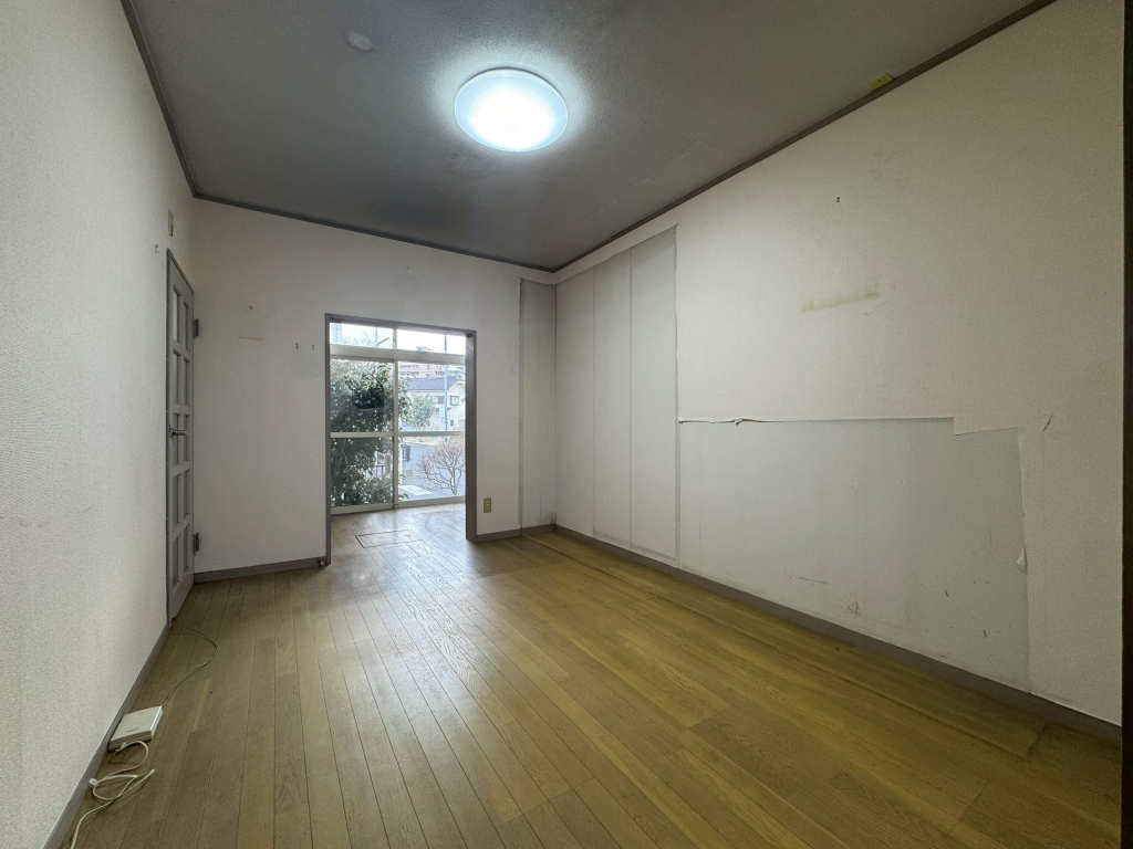 1階洋室8帖、奥にはキッチンがございます。